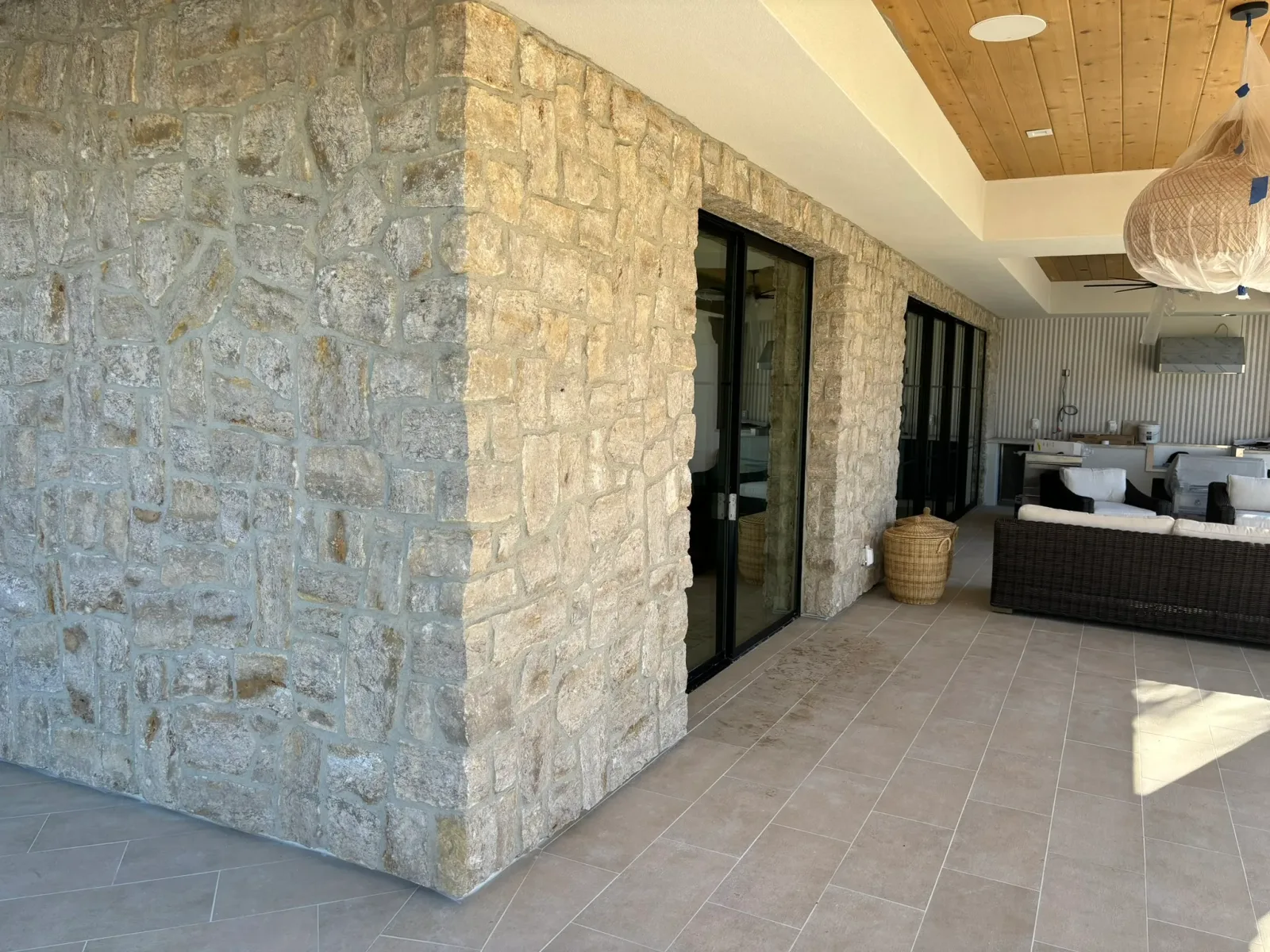 Rancho Santa Fe estate backyard with stone walls, oak trees, and pavilion outdoor kitchen
