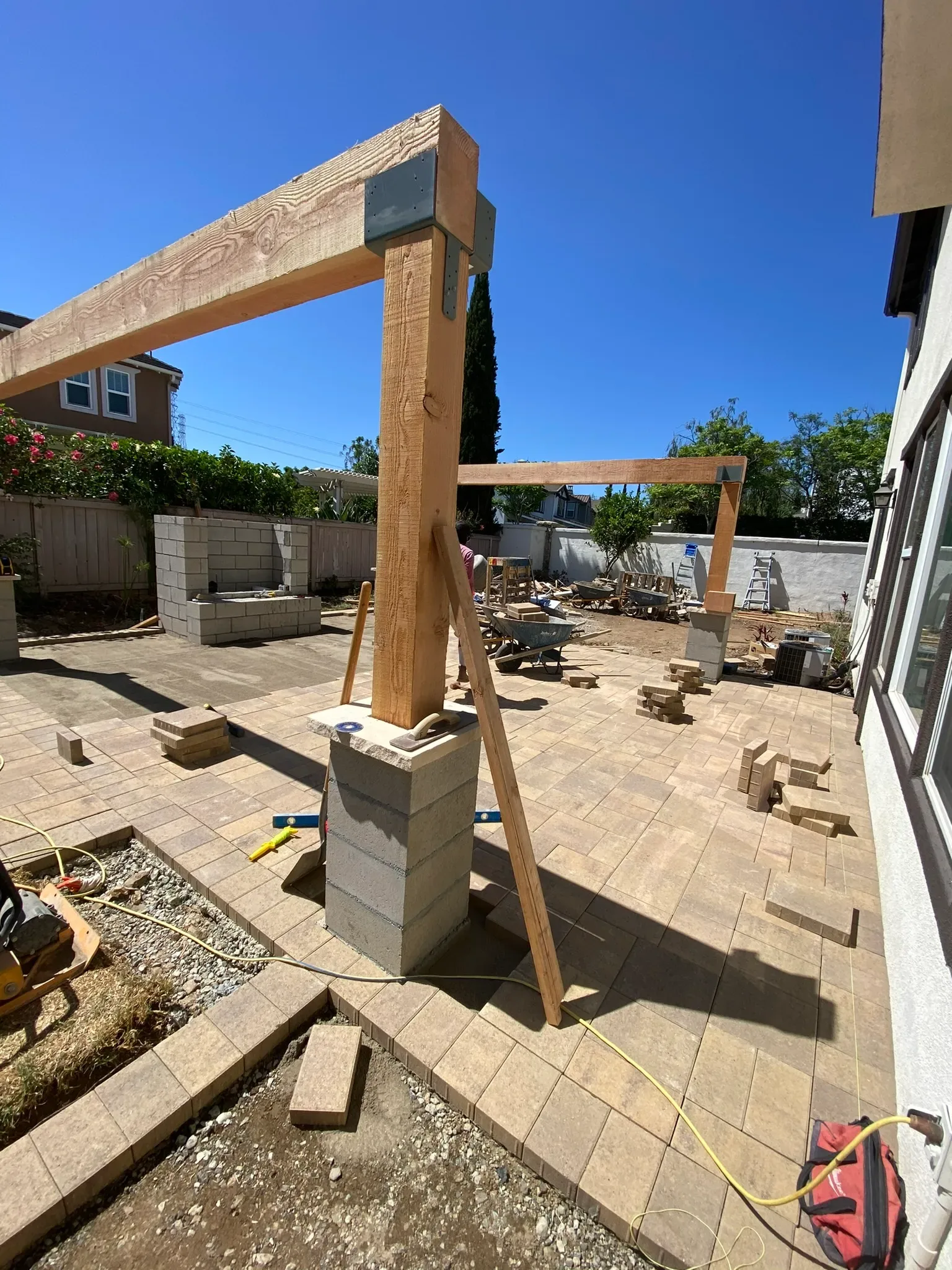 Outdoor kitchen, fire pit, and louvered patio cover in a San Marcos backyard