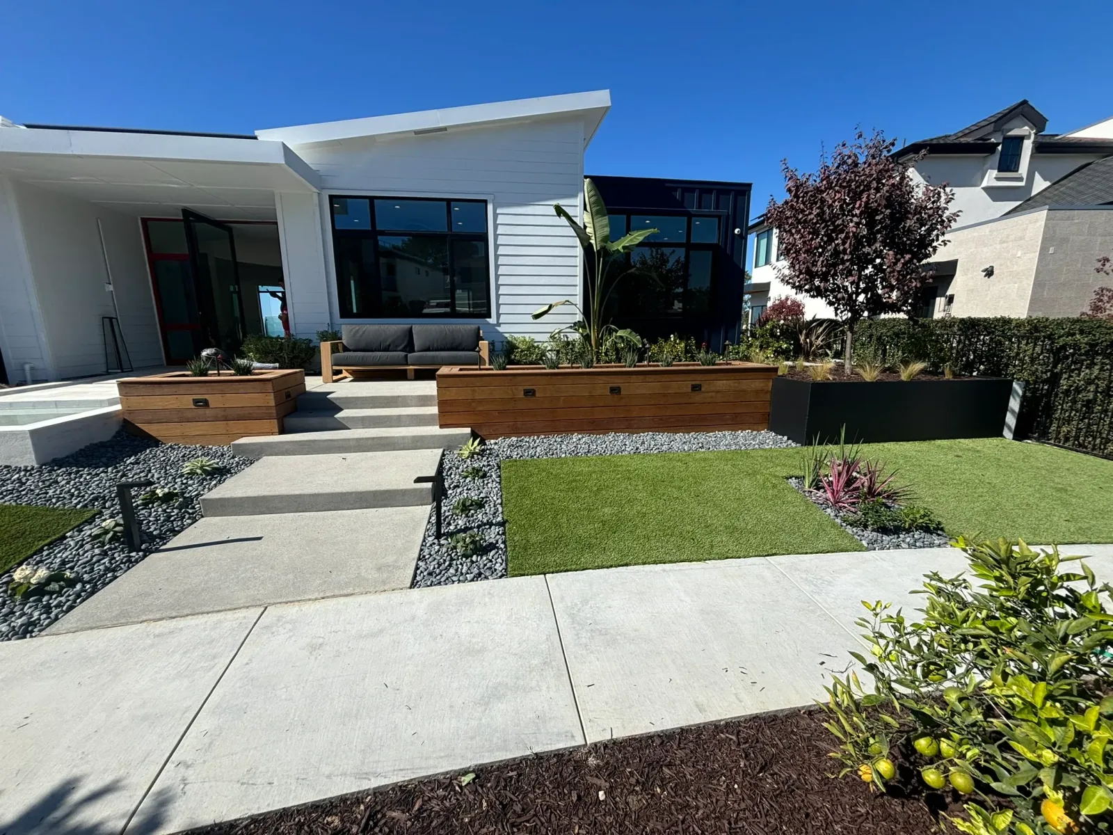 Vista CA backyard with paver patio, retaining wall, and drought-tolerant planting on a hillside lot